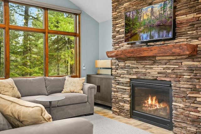 living room featuring lofted ceiling, a fireplace, and light hardwood / wood-style flooring