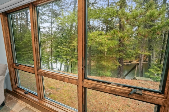 doorway featuring tile patterned flooring, a water view, and plenty of natural light