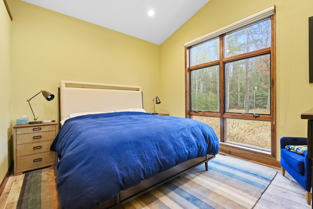 bedroom with multiple windows, vaulted ceiling, and light hardwood / wood-style flooring