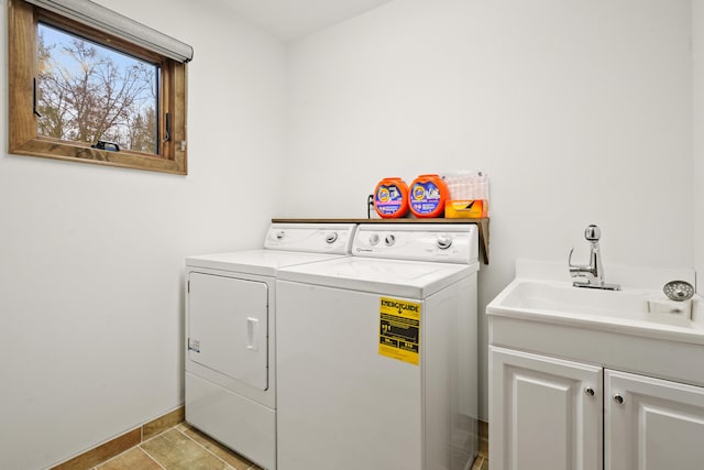 laundry room featuring cabinets, light tile patterned flooring, sink, and independent washer and dryer