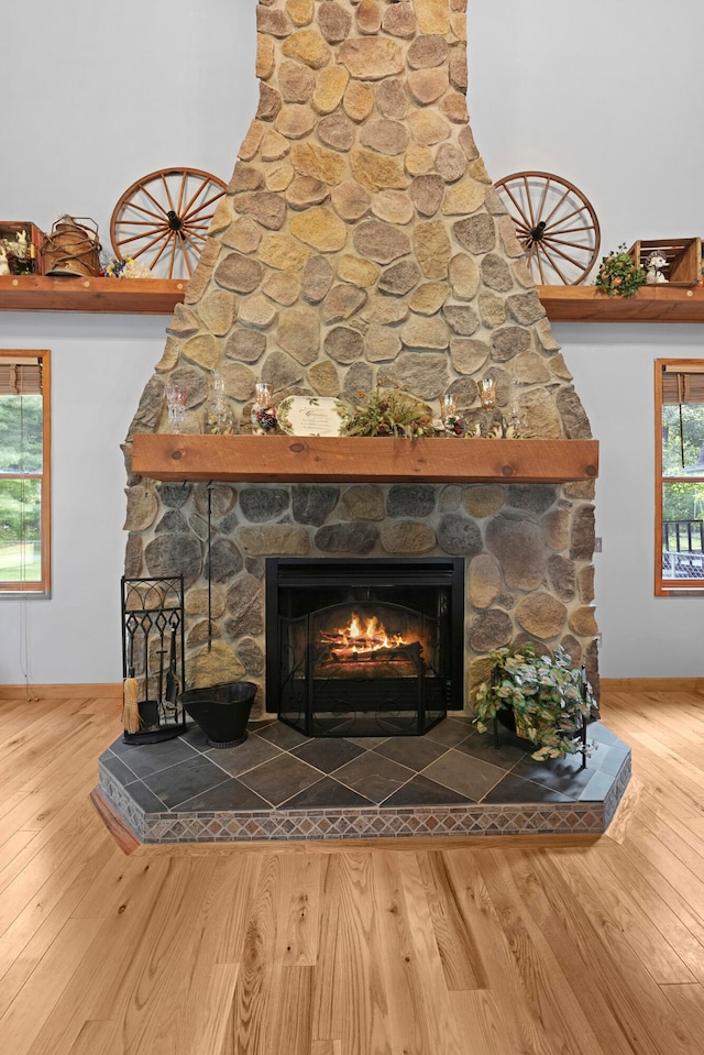 room details with hardwood / wood-style flooring and a stone fireplace