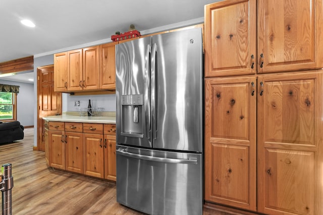 kitchen featuring stainless steel fridge and light hardwood / wood-style flooring