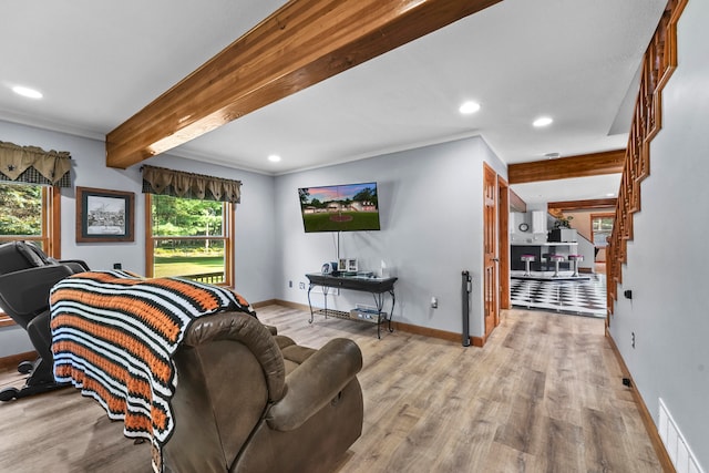 living room with light hardwood / wood-style floors, beam ceiling, and ornamental molding