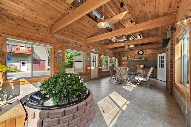 sunroom featuring ceiling fan, vaulted ceiling with beams, and wood ceiling