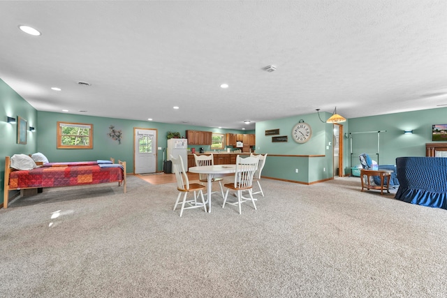 carpeted dining room with a textured ceiling