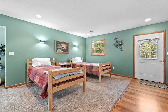 bedroom with light hardwood / wood-style floors and multiple windows