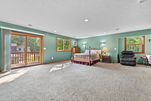 carpeted bedroom featuring access to outside, a textured ceiling, and multiple windows