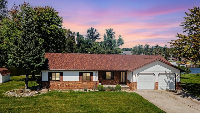 ranch-style home with a garage and a yard