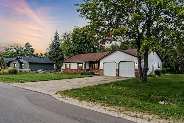 ranch-style house with a garage and a yard