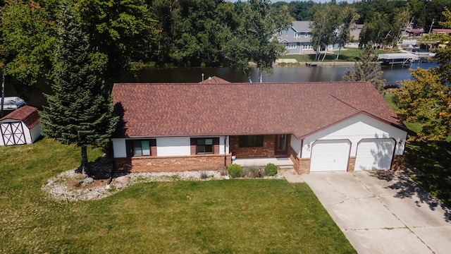 view of front of house featuring a water view, a garage, and a front yard