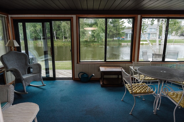 sunroom / solarium featuring wood ceiling, a water view, and a healthy amount of sunlight