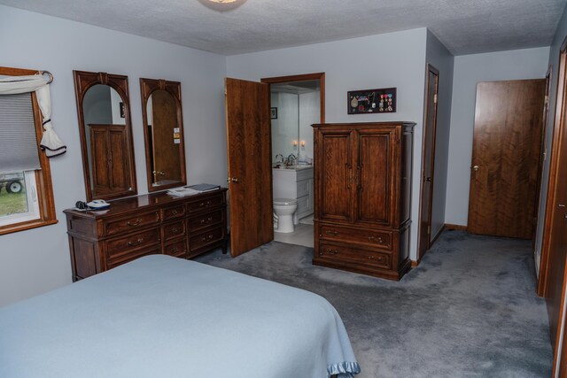 bedroom featuring sink, ensuite bathroom, carpet floors, and a textured ceiling