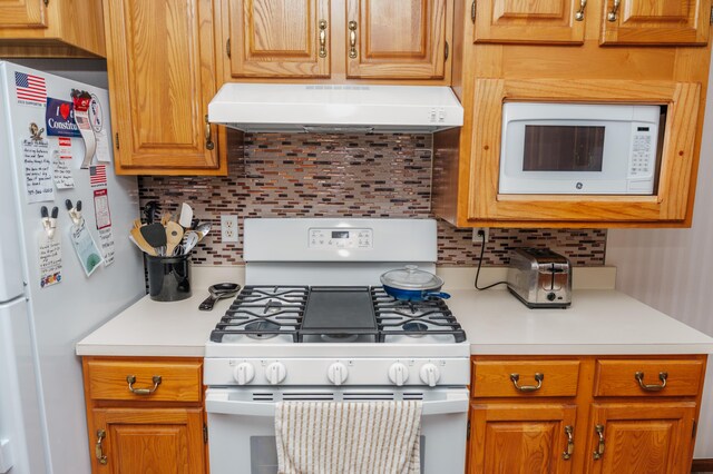 kitchen featuring backsplash and white appliances