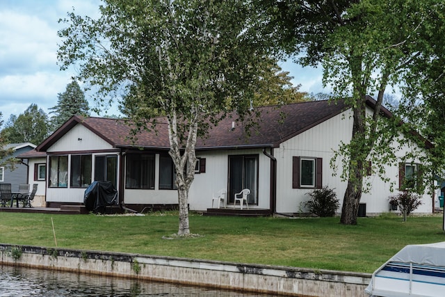 view of front facade featuring a sunroom and a front lawn