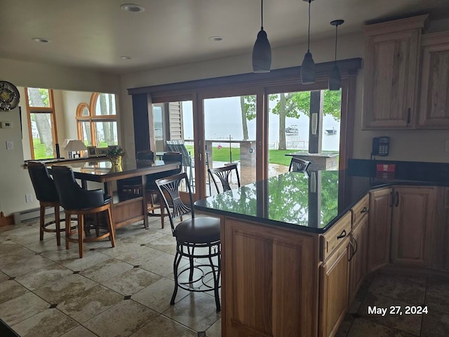 kitchen with tile patterned floors, decorative light fixtures, a breakfast bar area, and baseboard heating