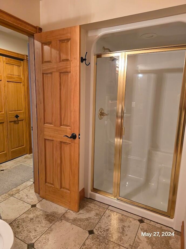 bathroom with tile patterned floors and an enclosed shower