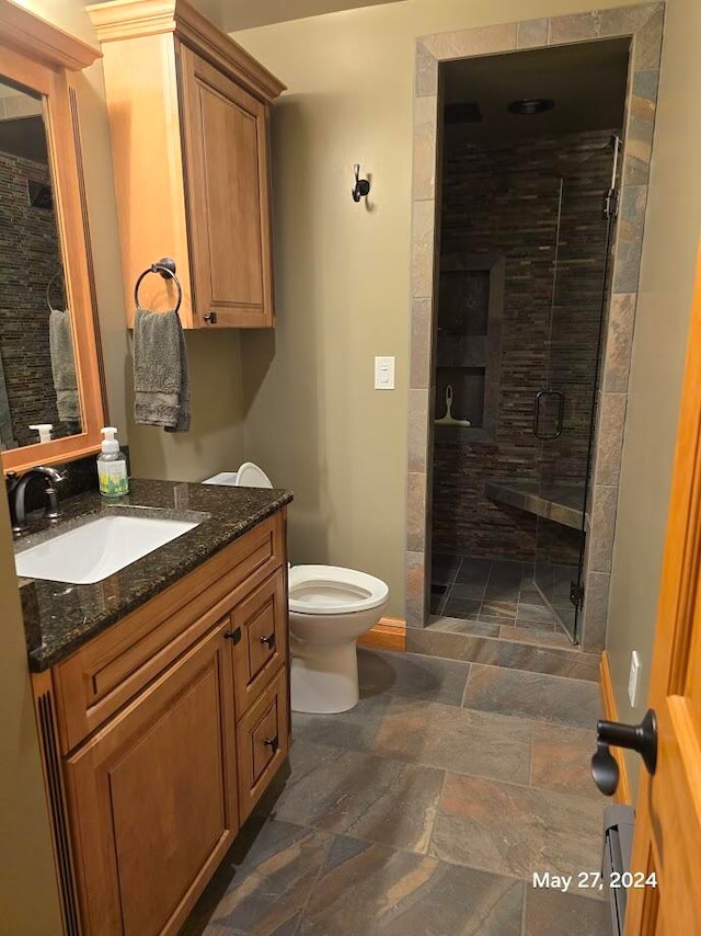 bathroom with tile patterned floors, toilet, an enclosed shower, and vanity