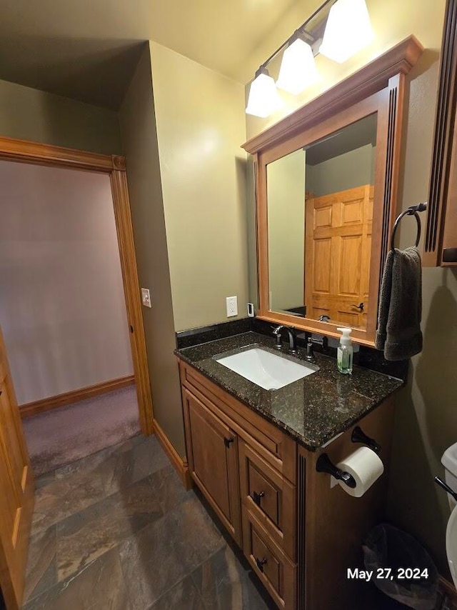 bathroom with toilet, tile patterned flooring, and vanity