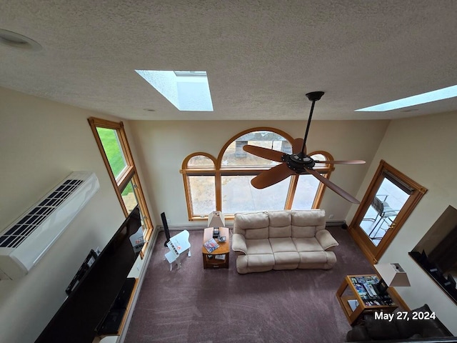 unfurnished living room featuring a high ceiling, a skylight, a textured ceiling, carpet flooring, and ceiling fan