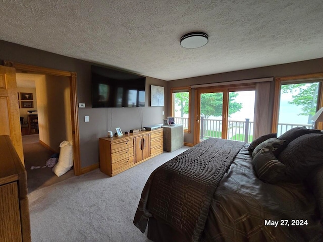 carpeted bedroom featuring a textured ceiling and access to outside