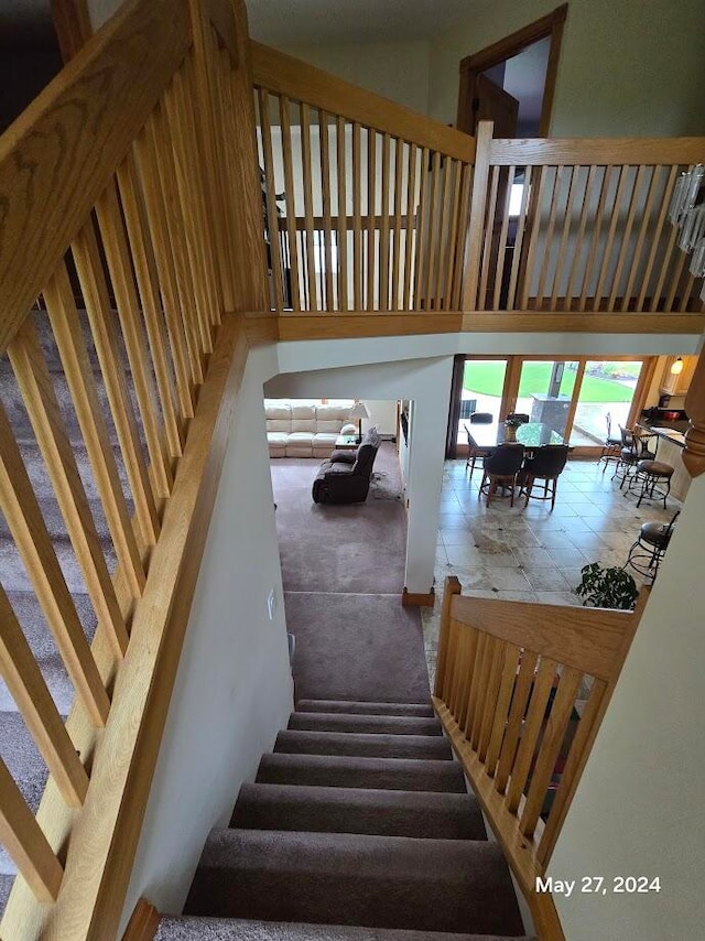 staircase featuring tile patterned floors and a high ceiling