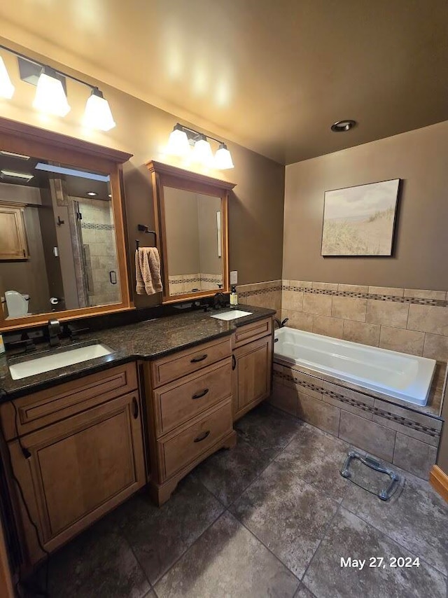 bathroom with tile patterned floors, vanity, and shower with separate bathtub