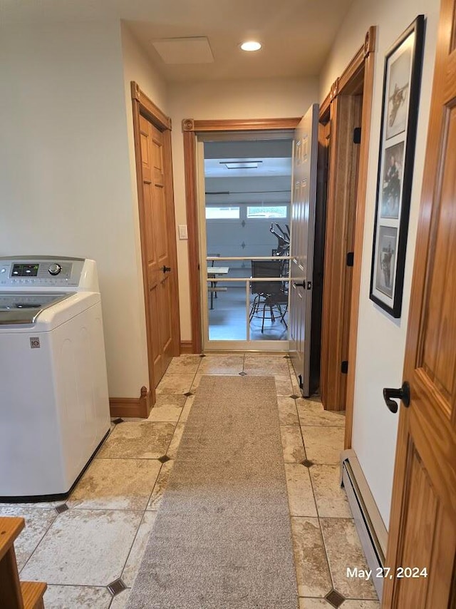 clothes washing area featuring washer / clothes dryer, light tile patterned floors, and a baseboard radiator