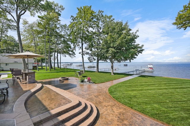 view of patio with a boat dock, a fire pit, and a water view