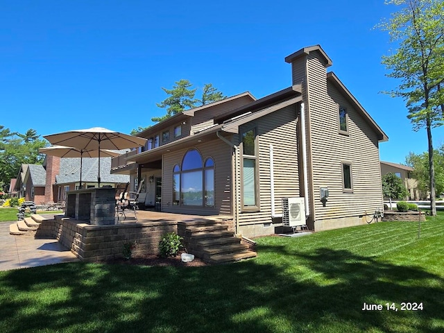 rear view of house with a patio and a lawn