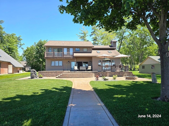 exterior space featuring a balcony, a patio area, and a lawn