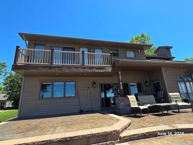 view of front of home with a balcony and a patio area