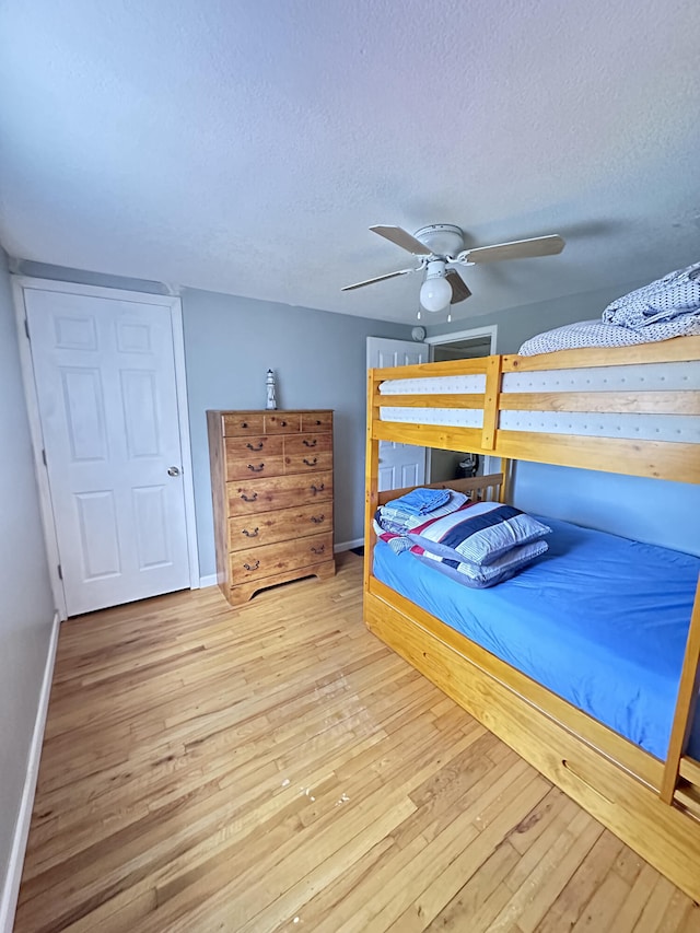 unfurnished bedroom featuring ceiling fan, a textured ceiling, and light hardwood / wood-style floors