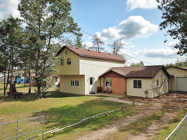 back of property featuring a lawn and a garage