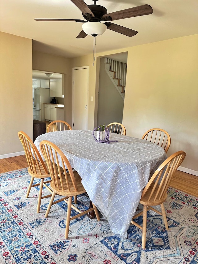 dining space with ceiling fan and hardwood / wood-style flooring