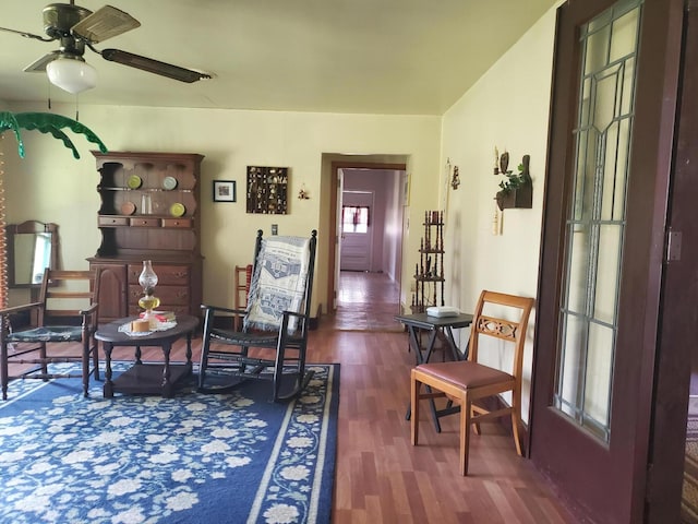 living area featuring ceiling fan, plenty of natural light, and dark hardwood / wood-style floors