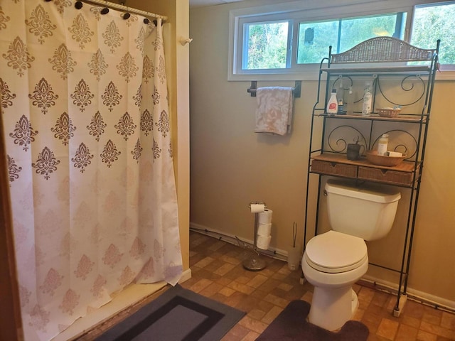 bathroom featuring toilet, tile patterned flooring, and curtained shower