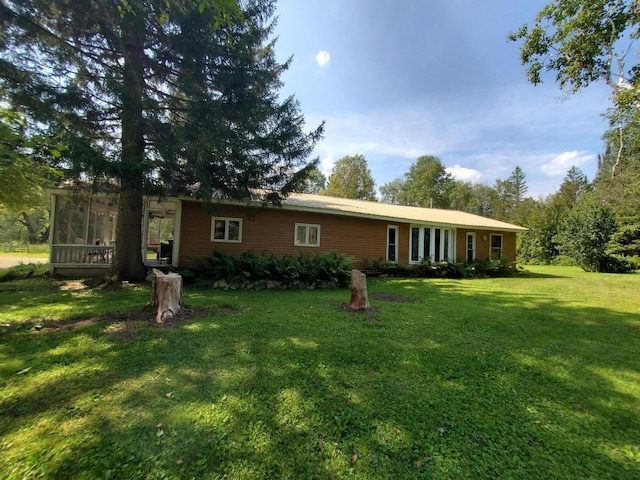 single story home featuring a front lawn and a sunroom