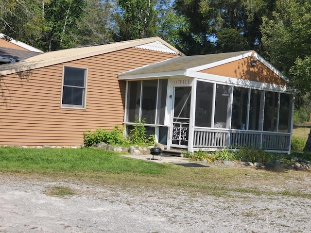 rear view of house featuring a sunroom