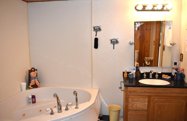 bathroom featuring a washtub, vanity, and toilet