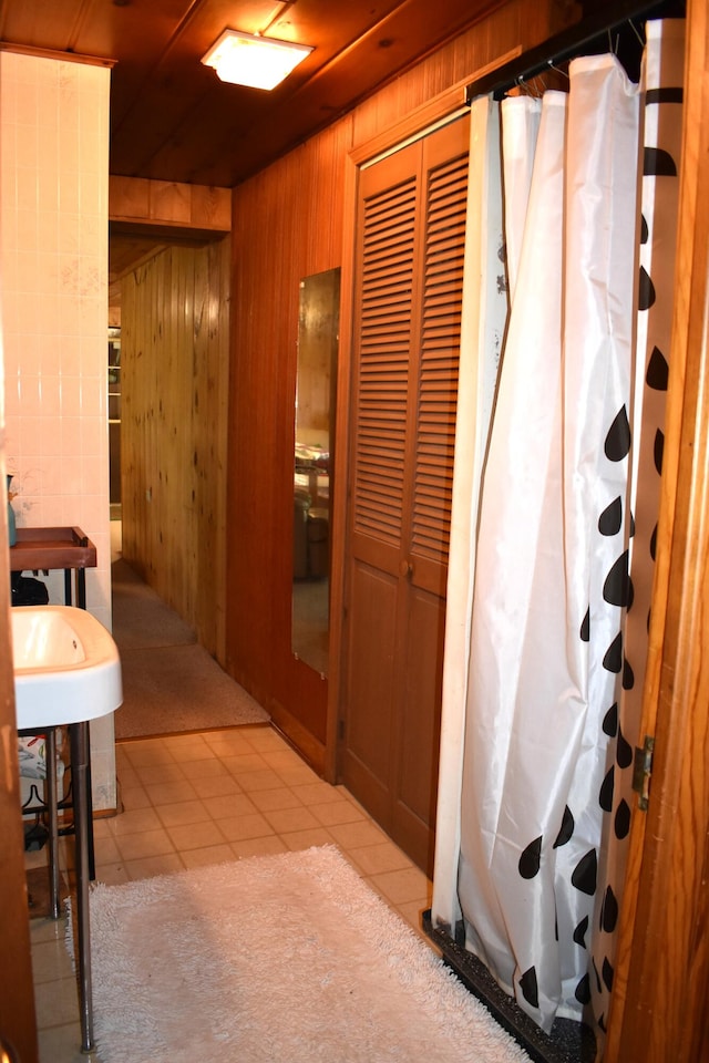 bathroom with wood walls, walk in shower, and tile patterned floors