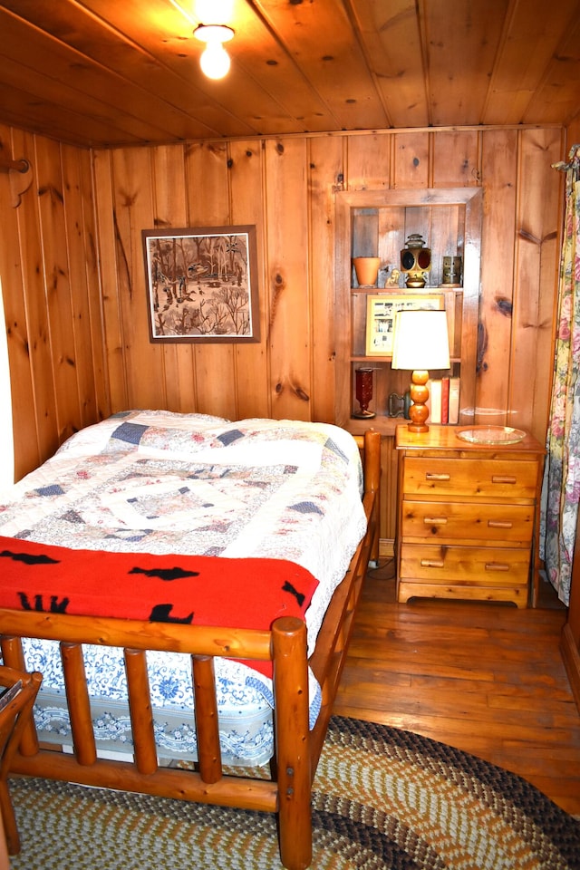 bedroom with wooden walls, wooden ceiling, and hardwood / wood-style floors