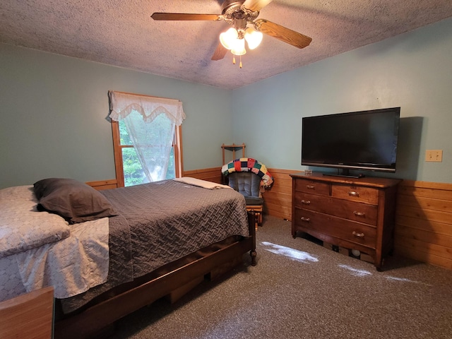 bedroom featuring ceiling fan, a textured ceiling, and carpet