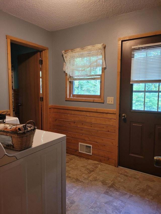 clothes washing area with tile patterned flooring, a textured ceiling, and washer / dryer