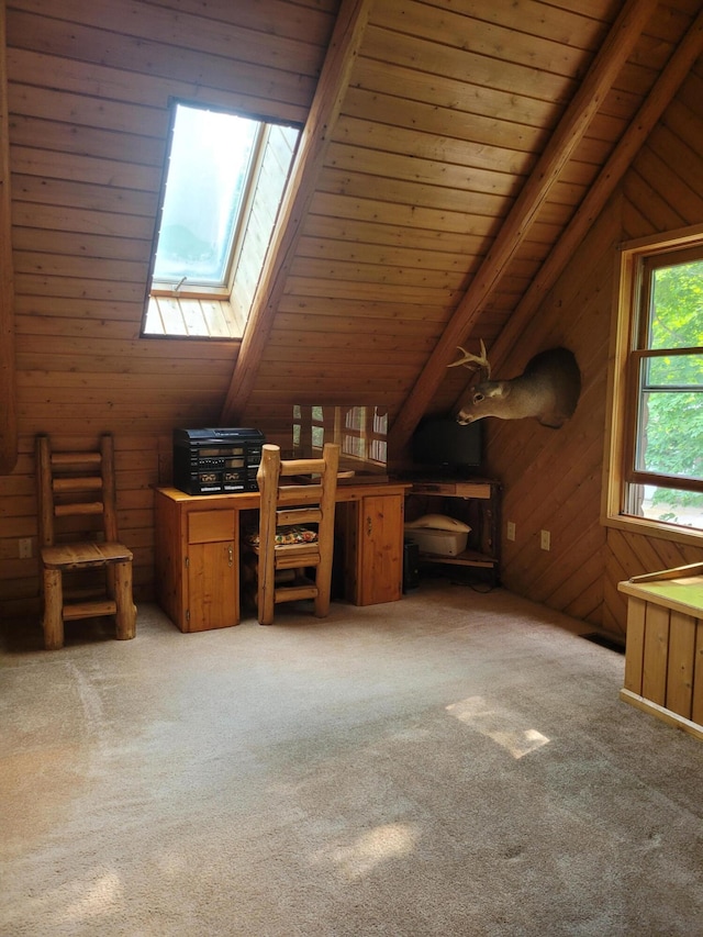 additional living space featuring wooden walls, lofted ceiling with skylight, and carpet floors