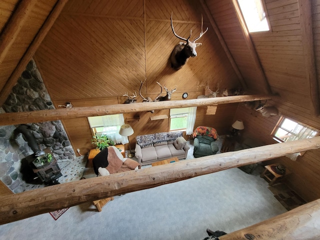 unfurnished living room featuring wood ceiling, beam ceiling, carpet, and high vaulted ceiling