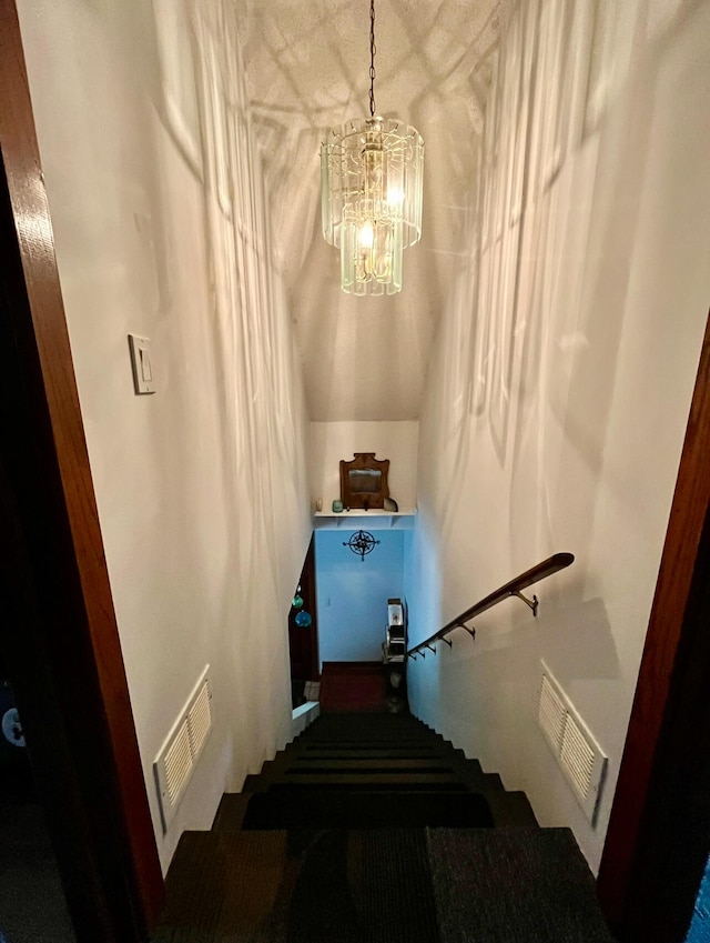 stairs with an inviting chandelier