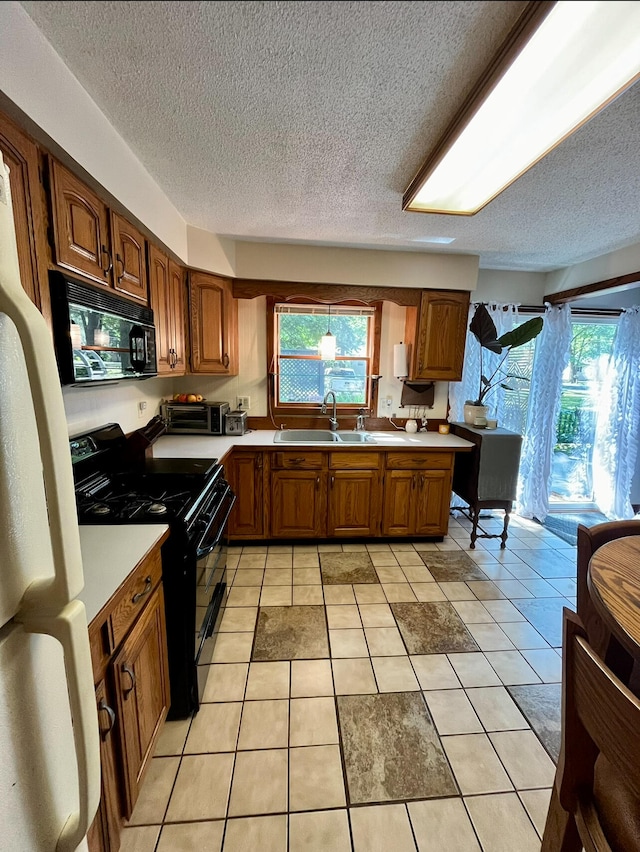 kitchen featuring sink, a textured ceiling, black appliances, and light tile patterned flooring