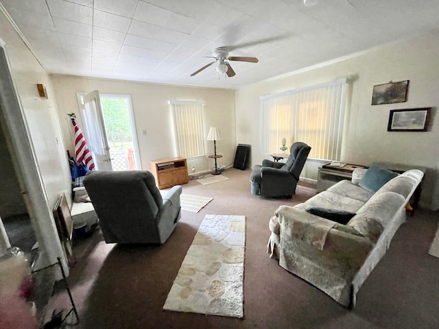 living room with dark colored carpet, ceiling fan, and ornamental molding