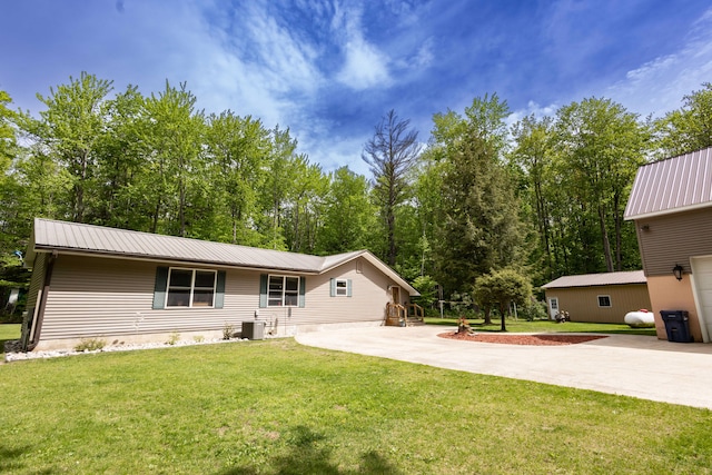 back of house featuring central AC unit and a lawn