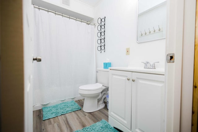 bathroom with wood-type flooring, a shower with shower curtain, crown molding, vanity, and toilet